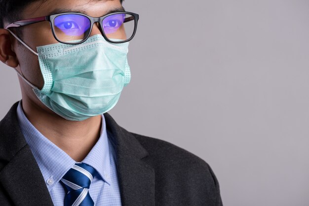 Foto empresario en un traje con mascarilla protectora