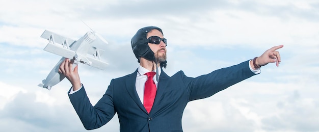 Empresario en traje y sombrero de piloto juguete de avión de lanzamiento