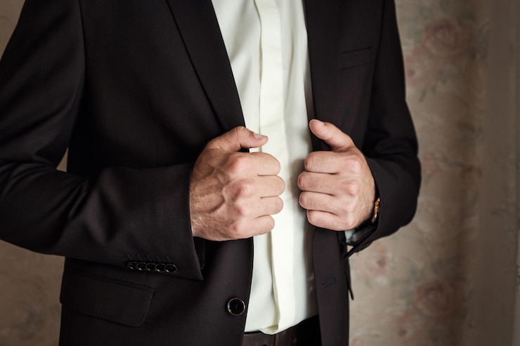 Empresário usa um casaco de mãos masculinas fechadas noivo se preparando de manhã antes da cerimônia de casamento