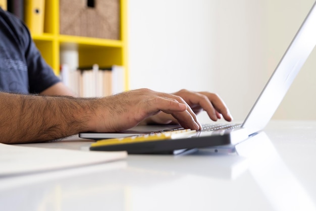 Empresario usando una computadora portátil y una calculadora Primer plano en las manos copia espacio escribiendo en el cuaderno