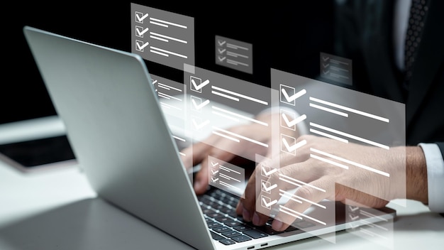 Empresario usando una computadora portátil mientras muestra un cuestionario con un icono de marca de comprobación Tabla en la mesa Innovación tecnológica en una pantalla virtual Concepto de cuestionario de examen en línea