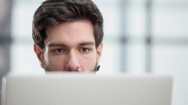 Empresario usando una computadora portátil mientras trabaja hasta tarde en su oficina