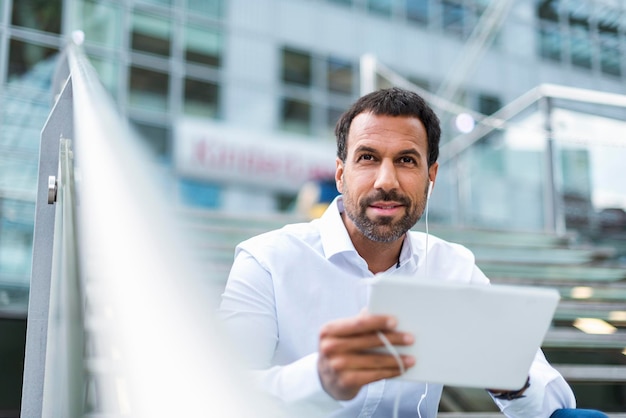 Empresário usando fones de ouvido tablet