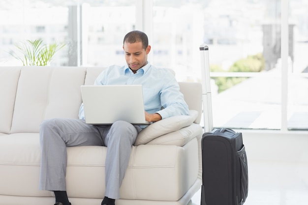 Empresário usando laptop esperando para partir em viagem de negócios