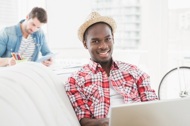 Empresário usando o laptop e olhando a câmera