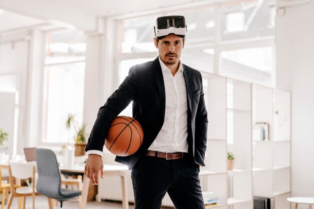 Empresário usando óculos VR segurando basquete no escritório