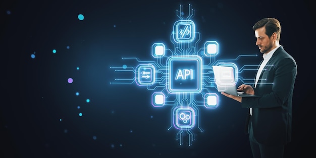 Empresario usando portátil con iconos de API brillantes y líneas de red de neón en fondo oscuro Concepto tecnológico