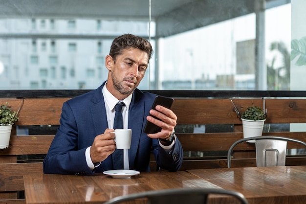 Empresário usando smartphone durante a pausa para o café