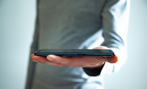 Empresário usando smartphone em fundo cinza isolado