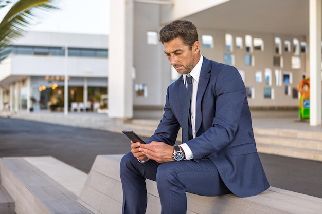 Empresário usando smartphone no banco na rua