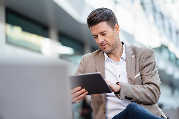 Empresário usando tablet ao ar livre