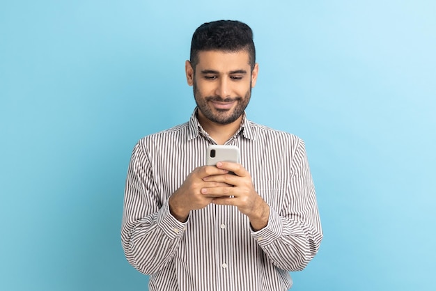 Empresario usando teléfono celular y sonriendo leyendo un mensaje de buenas noticias disfrutando de la aplicación móvil