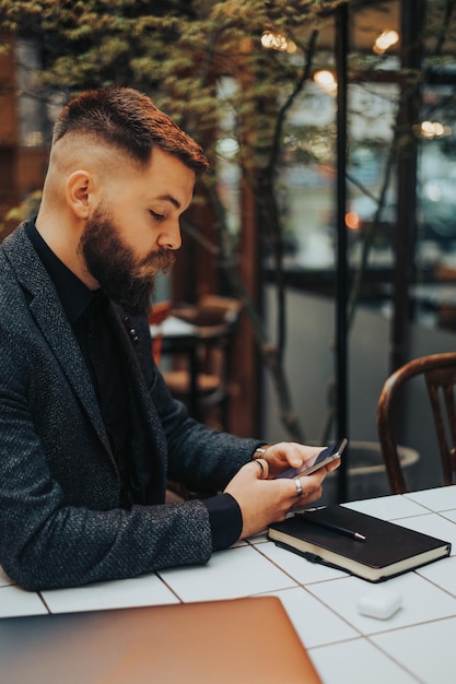 Empresário usando um smartphone enquanto trabalhava em um café