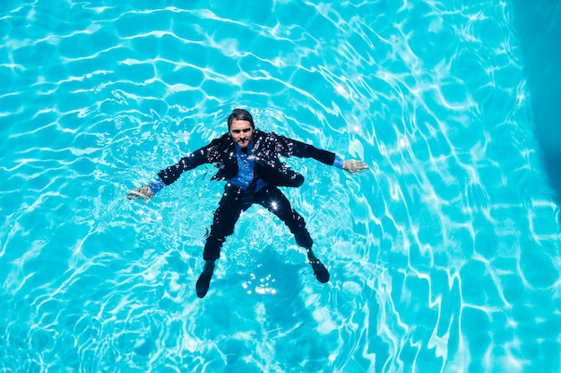 Empresário vestido na piscina