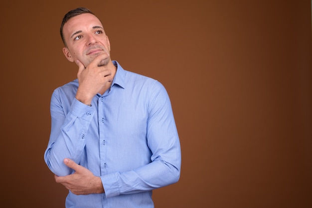 empresario vistiendo camisa azul sobre marrón