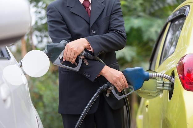 Empresários abastecendo a bomba de gasolina.