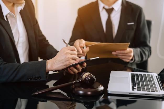 Foto empresarios y abogados discutiendo documentos contractuales sentados en la mesa conceptos de servicios legales de asesoramiento legal en la mañana lightxa