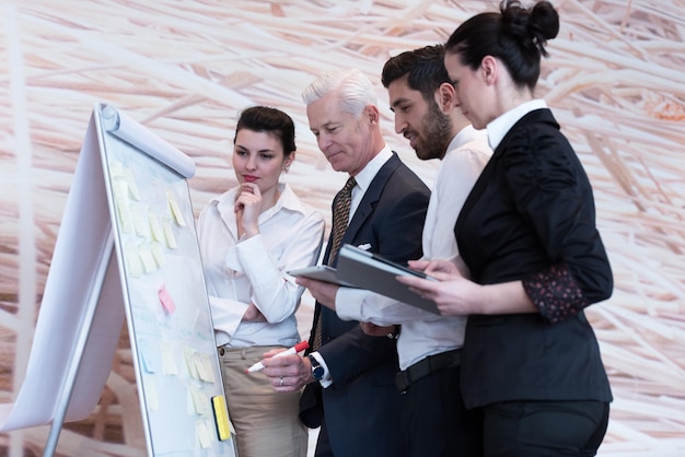 los empresarios agrupan la lluvia de ideas sobre la reunión y los empresarios presentan ideas y proyectos en flipboard al director general senior, el jefe da tareas y proyectos a los empleados