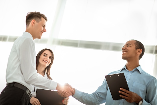 Empresários amigáveis apertando as mãos no fundo desfocado