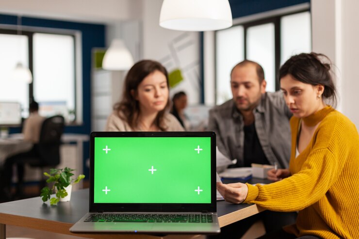 Foto empresarios analizando informes financieros anuales sentados en el escritorio en la parte posterior de la computadora portátil con pantalla verde chroma key, simulacros de escritorio