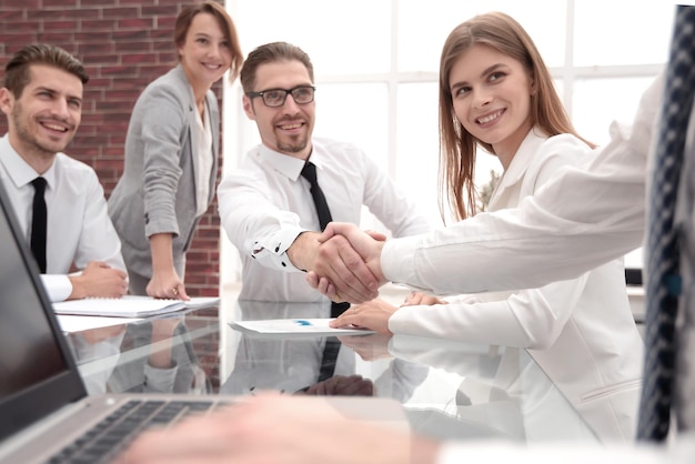 Empresários apertando as mãos na mesa de escritório conceito de cooperação