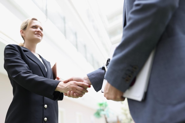 Empresários apertando as mãos no saguão do prédio