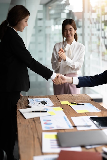 Foto empresários apertando as mãos terminando de conhecer o conceito de fusão e aquisição de felicitações de etiqueta empresarial