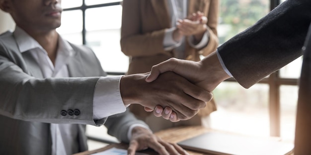 Empresários apertando as mãos terminando de conhecer o conceito de fusão e aquisição de felicitações de etiqueta empresarial