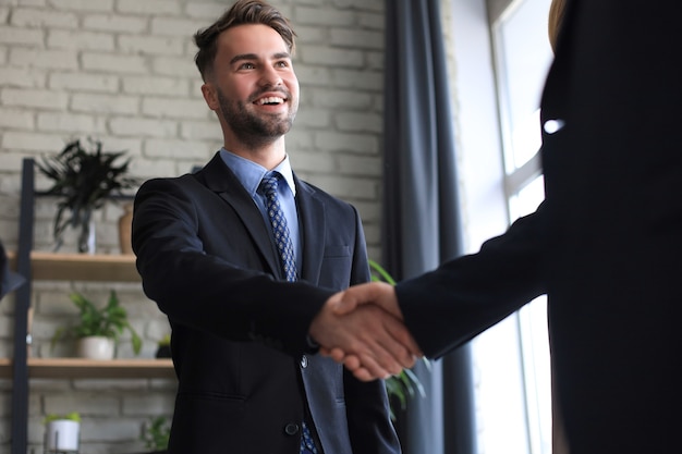 Empresários apertando as mãos, terminando uma reunião.