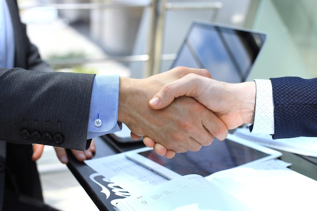 Empresários apertando as mãos, terminando uma reunião.