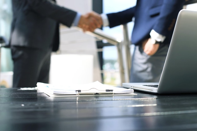 Empresários apertando as mãos, terminando uma reunião.