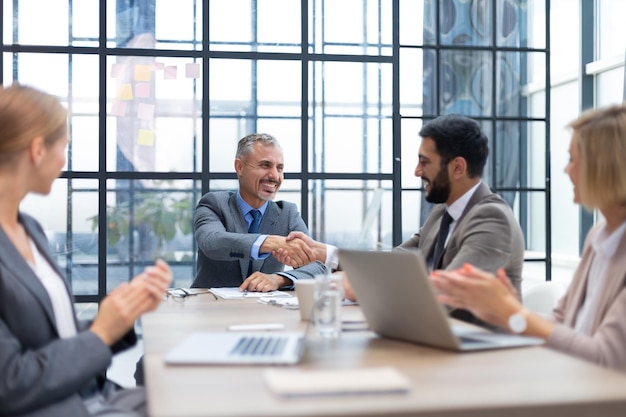 Empresários apertando as mãos, terminando uma reunião