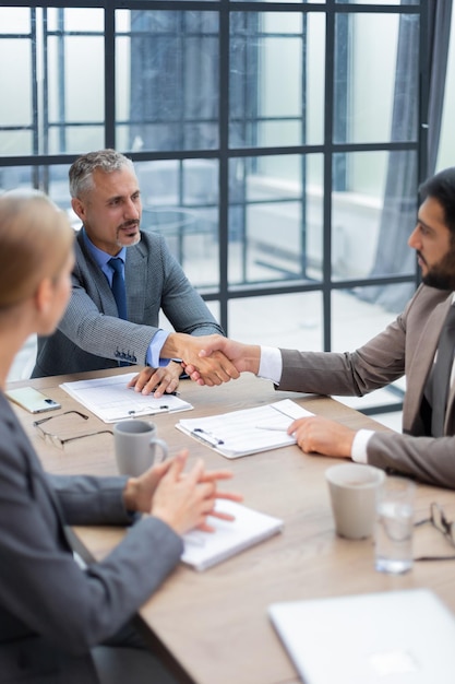 Foto empresários apertando as mãos, terminando uma reunião