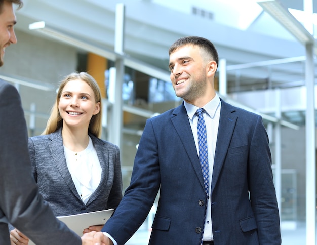 Empresários apertando as mãos, terminando uma reunião.