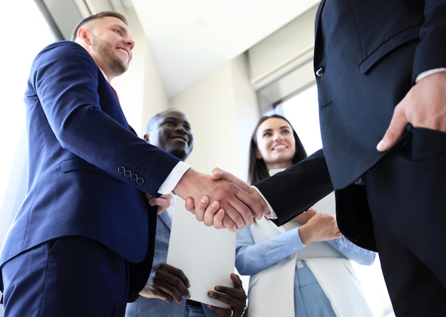 Empresários apertando as mãos, terminando uma reunião