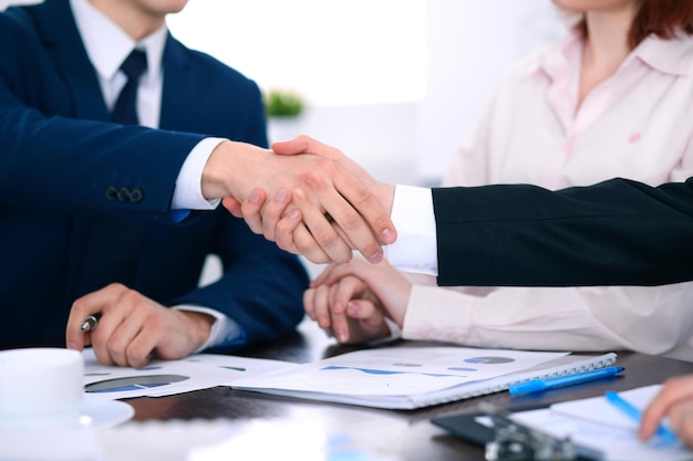Empresários apertando as mãos, terminando uma reunião