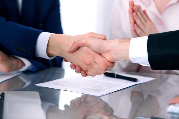 Empresários apertando as mãos, terminando uma reunião.