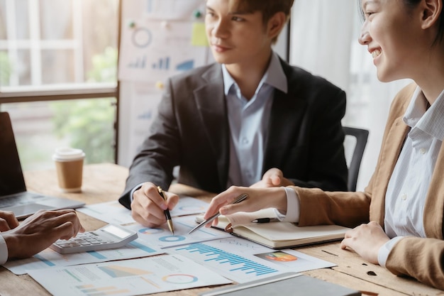 Empresarios asiáticos discutiendo sobre los ingresos por rendimiento al reunirse con un hombre de negocios que trabaja con un asesor financiero del equipo de compañeros que analiza datos con un inversor