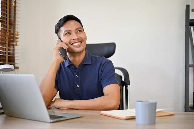 Empresarios asiáticos sonrientes teniendo una buena conversación por teléfono hablando por teléfono