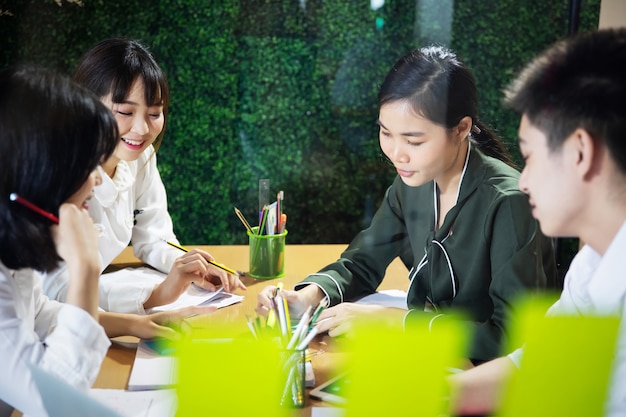 Empresarios asiáticos trabajando juntos en proyectos y lluvia de ideas en la oficina por la noche