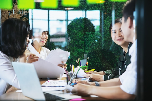 Empresarios asiáticos trabajando juntos en proyectos y lluvia de ideas en la oficina por la noche