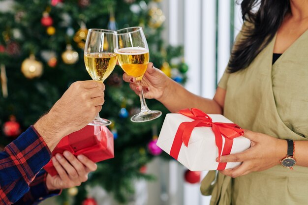 Foto empresários bebendo champanhe e trocando presentes de natal no escritório, depois do trabalho