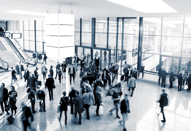 Empresarios borrosos corriendo en un pasillo en una feria comercial. ideal para diseños de sitios web y revistas