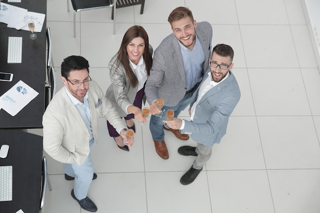 Empresários brindando com taças de champanhe no conceito de sucesso de escritório