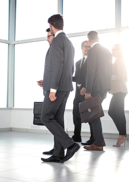 Empresários caminhando para o lado em um escritório moderno