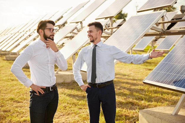 Empresarios en campo con paneles solares.