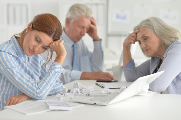 Empresários cansados trabalhando no escritório moderno e leve