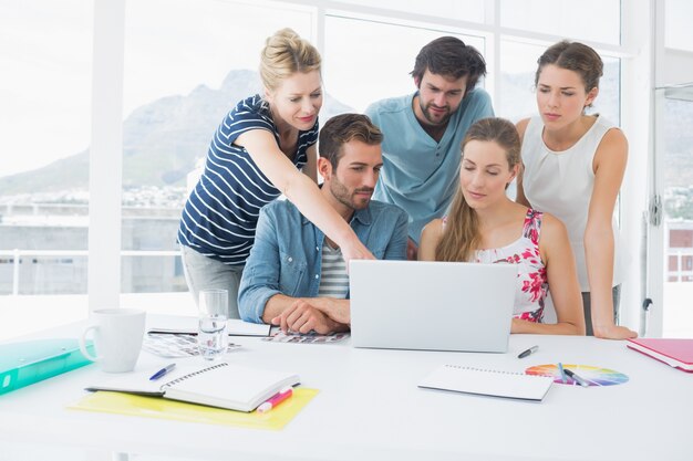 Empresários casuais que usam laptop juntos