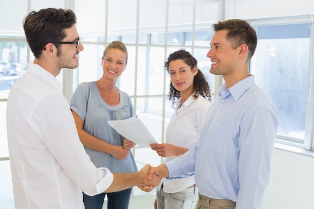 Empresarios casuales estrecharme la mano y sonriendo