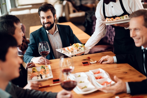 Los empresarios comen juntos en un restaurante.